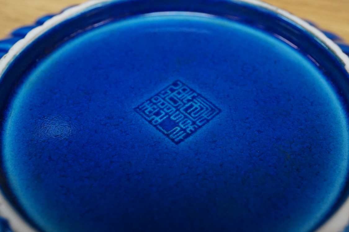 A Chinese blue glazed cylindrical brush pot, Kangxi mark but later, a similar saucer, Qianlong mark but later and a terracotta jug, 21cm